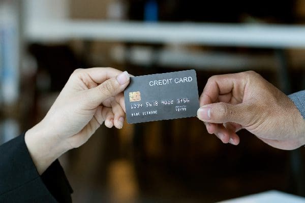 Two people exchanging a black credit card during a transaction