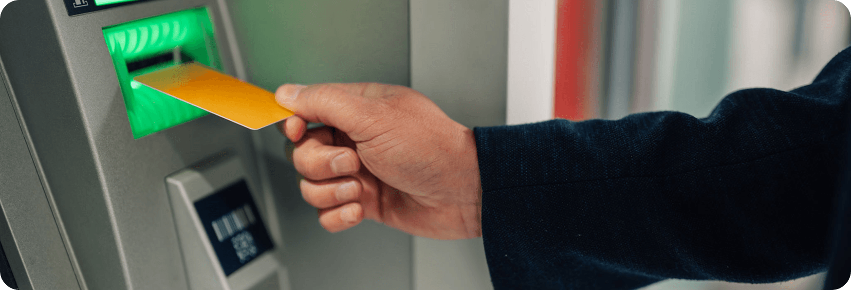 Inserting card into ATM machine slot.
